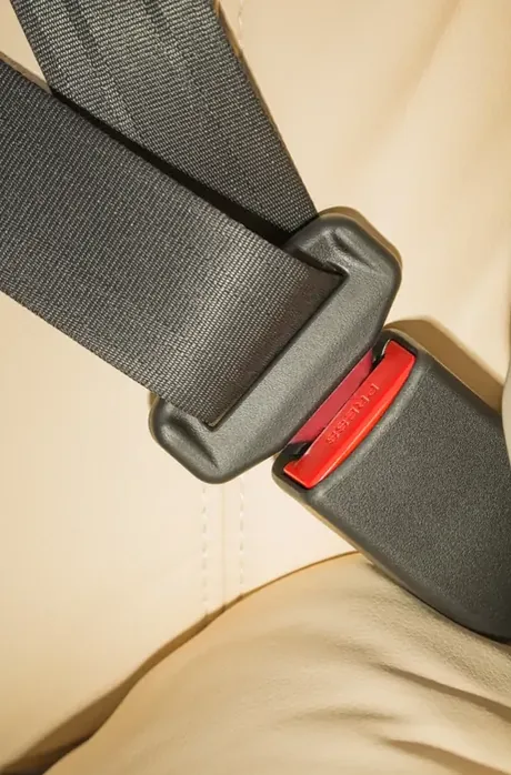Seat belt fastened across a seat, the webbing drawn taut by the retractor.
